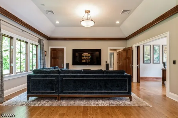 a living room with a balcony furniture and a flat screen tv