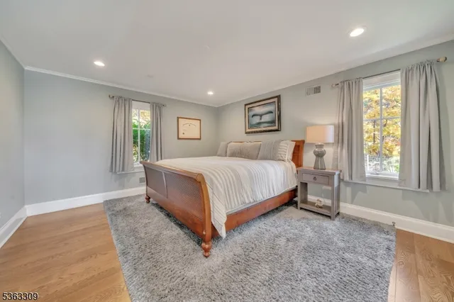a bedroom with a bed lamp and windows