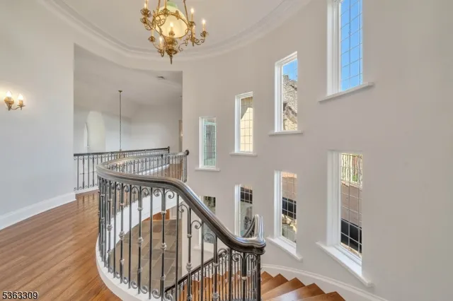 a view of staircase with railing and a chandelier