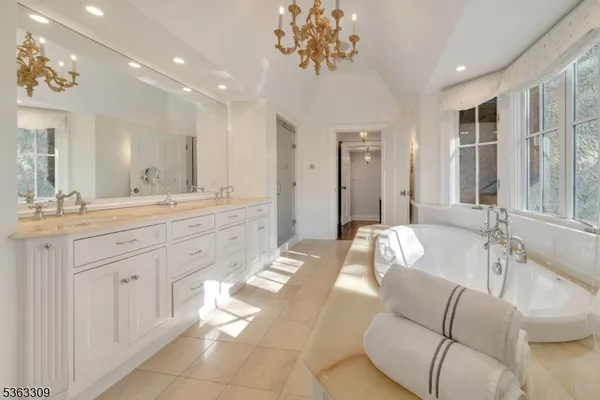 a spacious bathroom with a granite countertop sink a mirror a vanity and bathtub