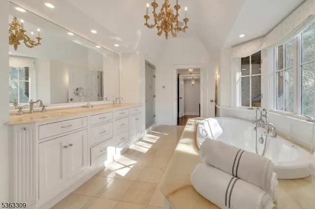 a spacious bathroom with a granite countertop sink a mirror a vanity and bathtub