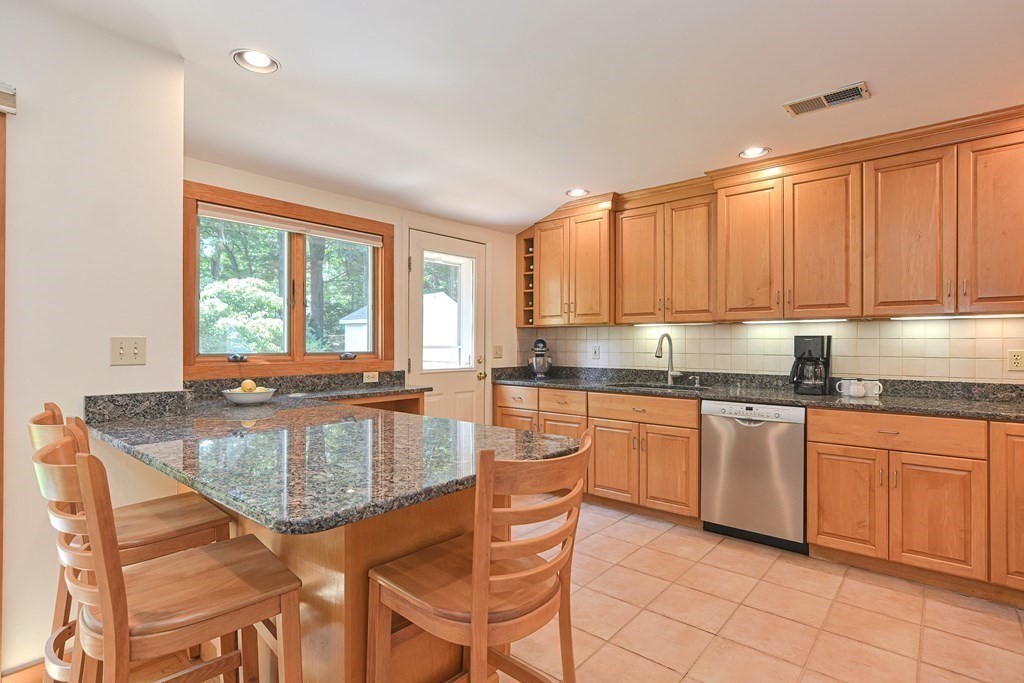 110 Richard Road Holliston, MA 01746 - Photo 14 of 41 a kitchen with stainless steel appliances granite countertop table chairs sink and cabinets