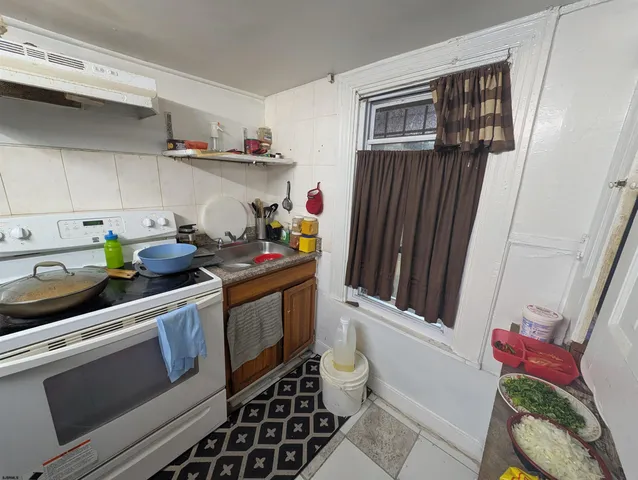 a kitchen with stainless steel appliances a sink a stove and cabinets