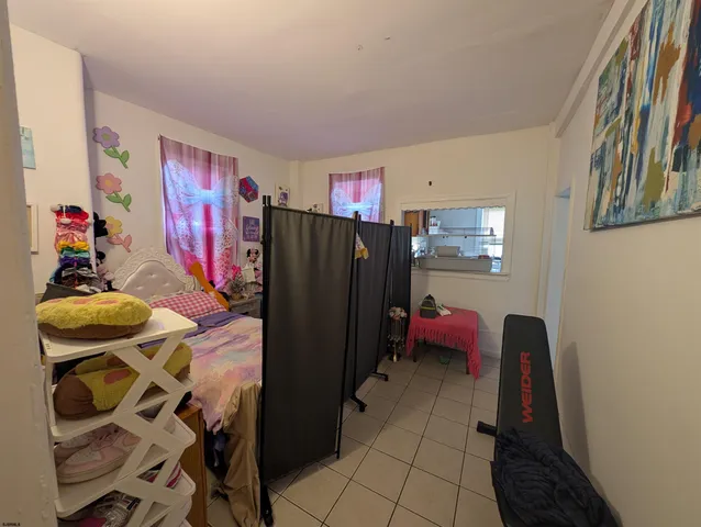 a living room with furniture and a refrigerator