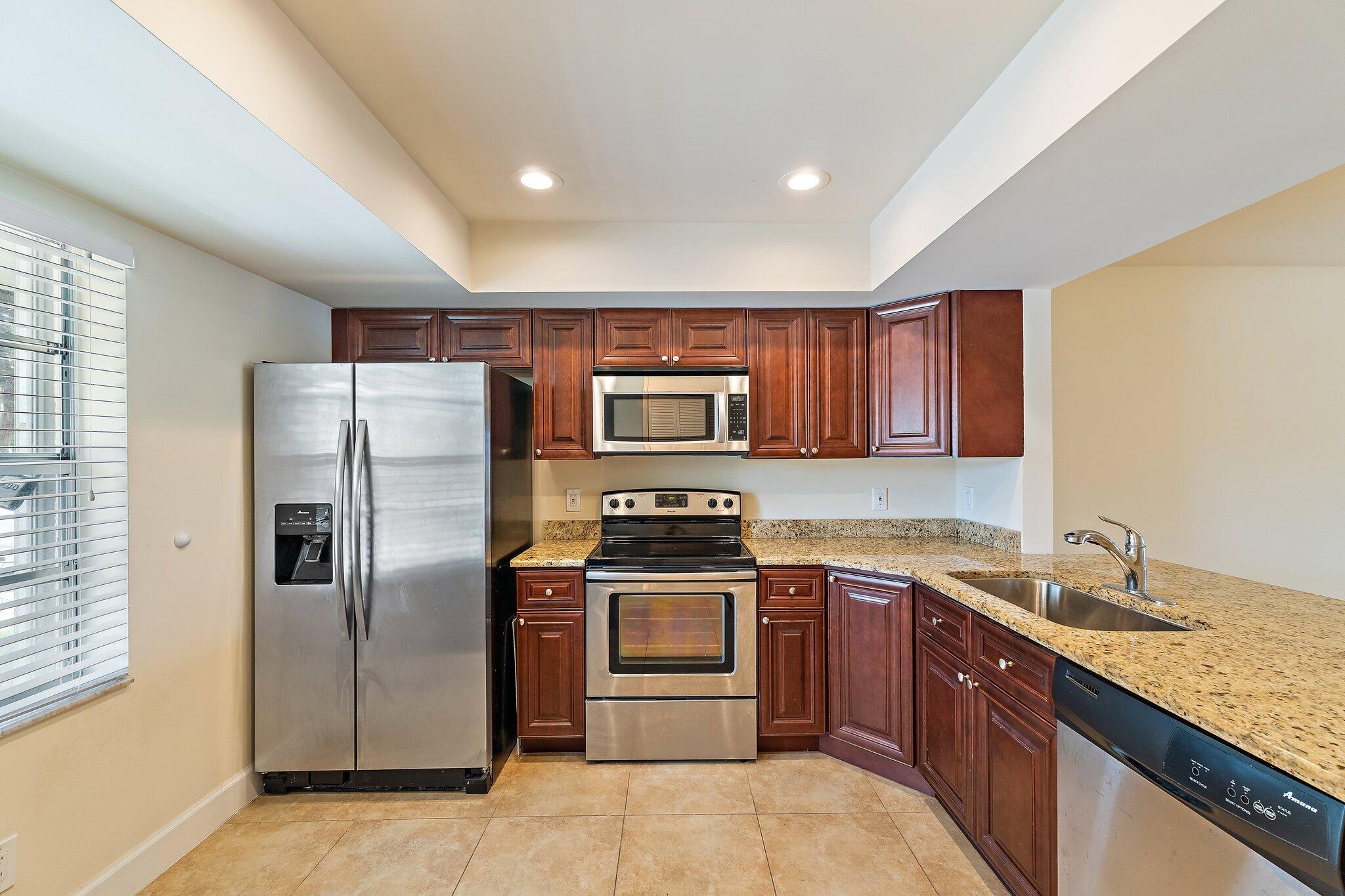 109 Doe Trail Jupiter, FL 33458 - Photo 5 of 26 a kitchen with stainless steel appliances granite countertop a refrigerator stove and sink