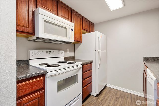 a kitchen with granite countertop white cabinets and white appliances