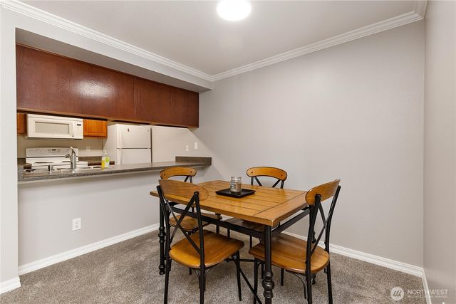 a view of a dining room with chairs and chandelier