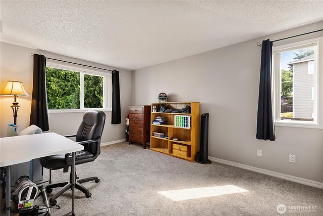 a view of a workspace with furniture and a window
