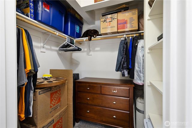 a view of walk in closet with clothes and shoes