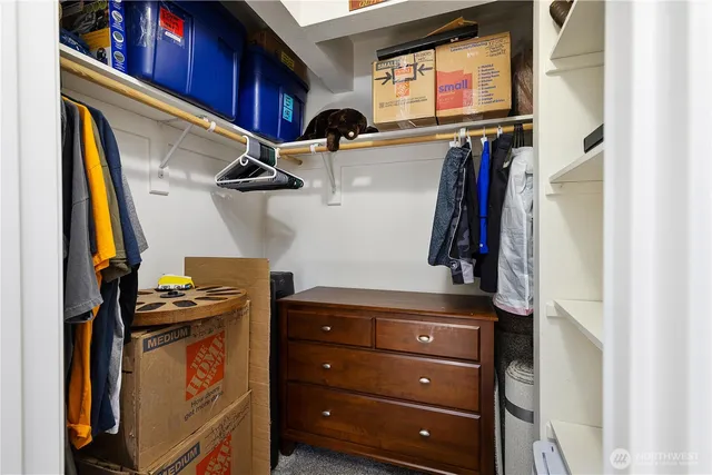 a view of walk in closet with clothes and shoes