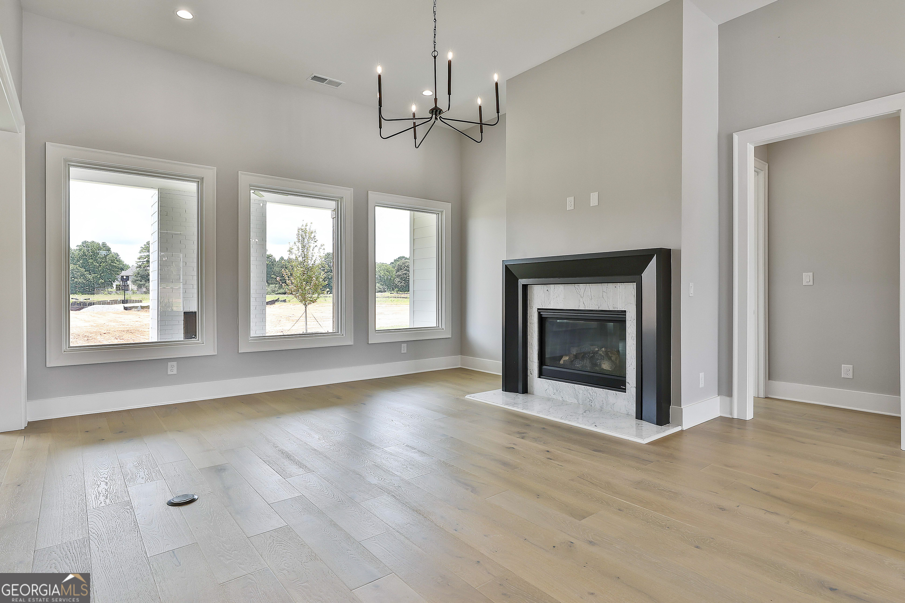 319 Ruffian Circle, Unit 71 Peachtree City, GA 30269 - Photo 12 of 43 wooden floor fireplace and windows in an empty room