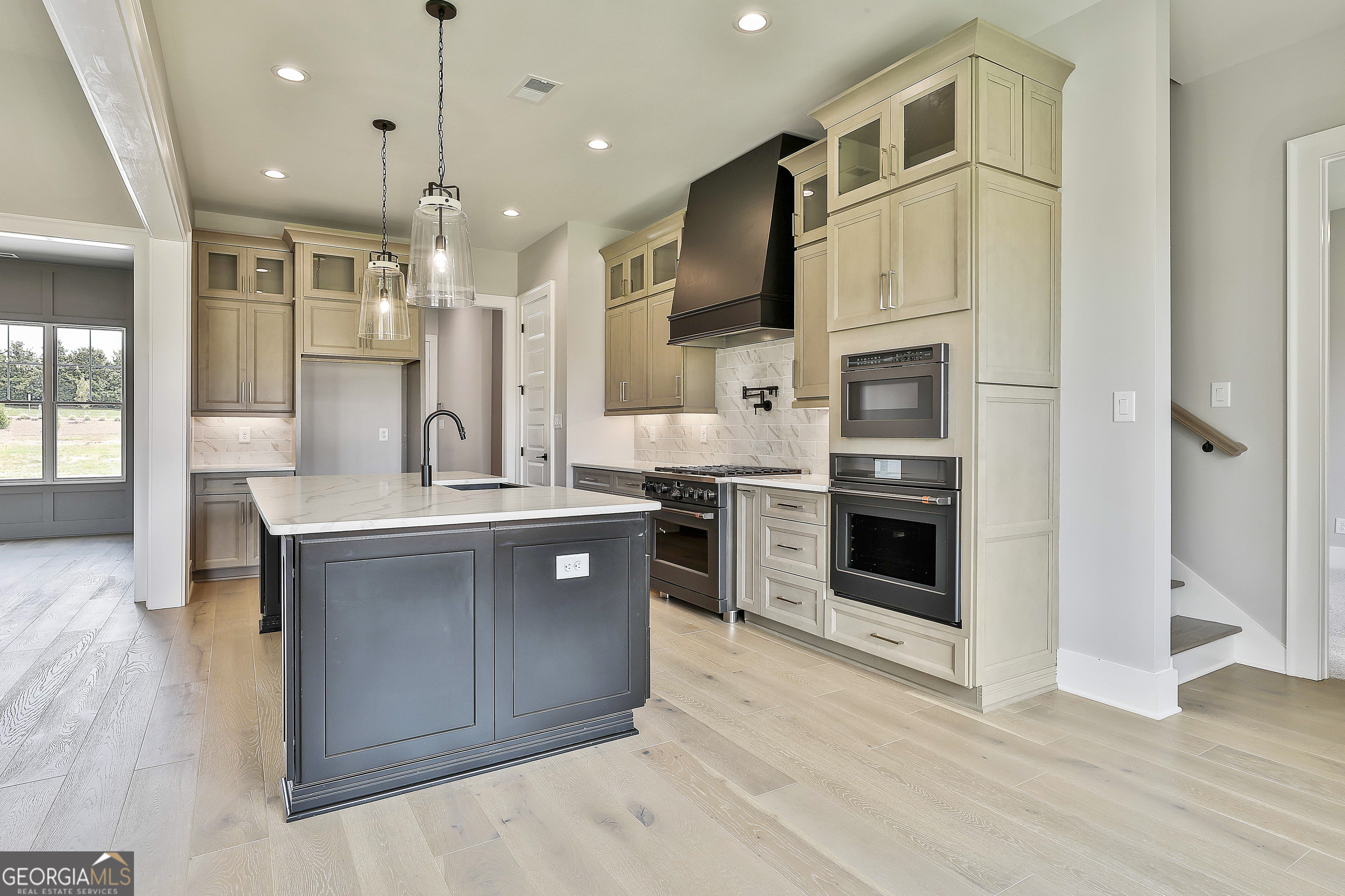 319 Ruffian Circle, Unit 71 Peachtree City, GA 30269 - Photo 16 of 43 a kitchen with stainless steel appliances kitchen island granite countertop a stove top oven a sink and a refrigerator