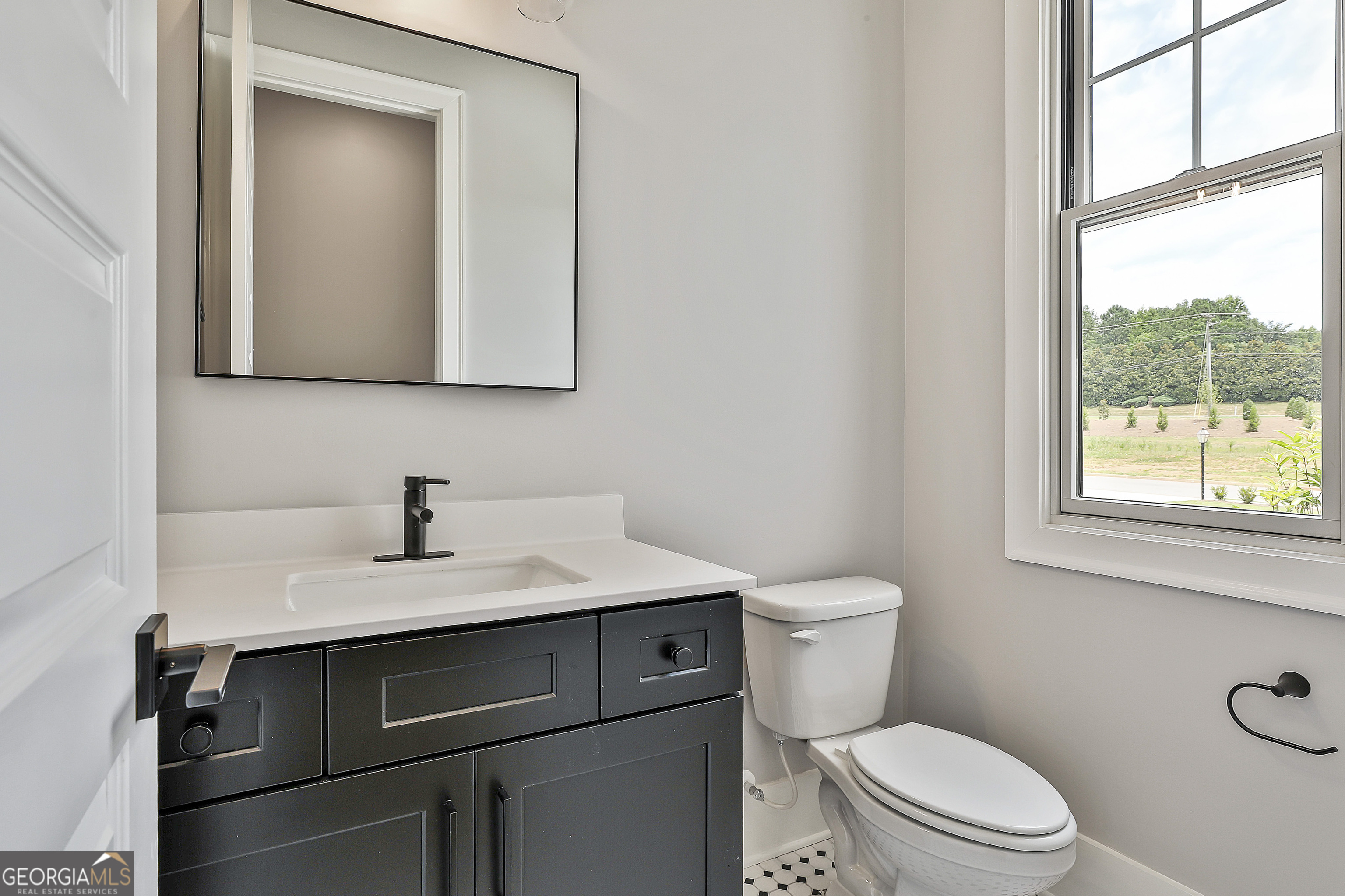 319 Ruffian Circle, Unit 71 Peachtree City, GA 30269 - Photo 22 of 43 a bathroom with a toilet sink vanity and mirror