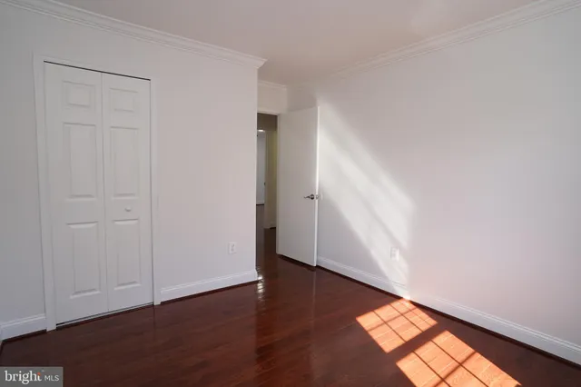an empty room with wooden floor and closet