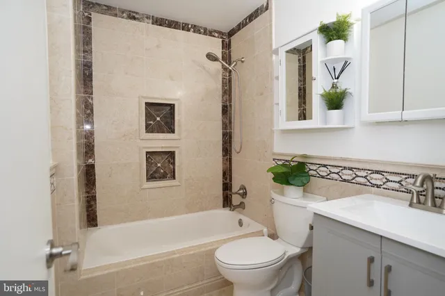 a bathroom with a bathtub shower sink mirror and toilet