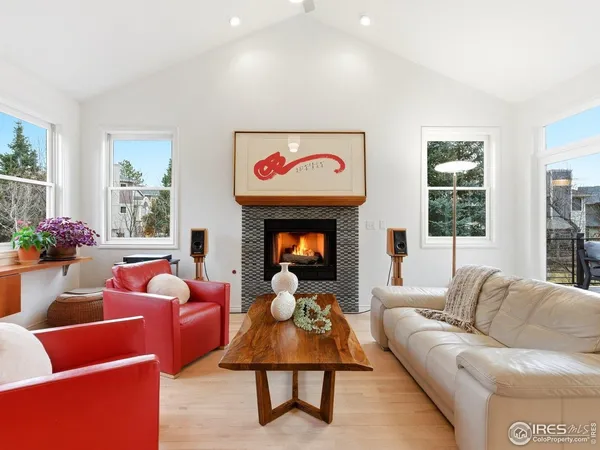 a open kitchen with stainless steel appliances granite countertop a sink dishwasher and a fireplace with wooden floor
