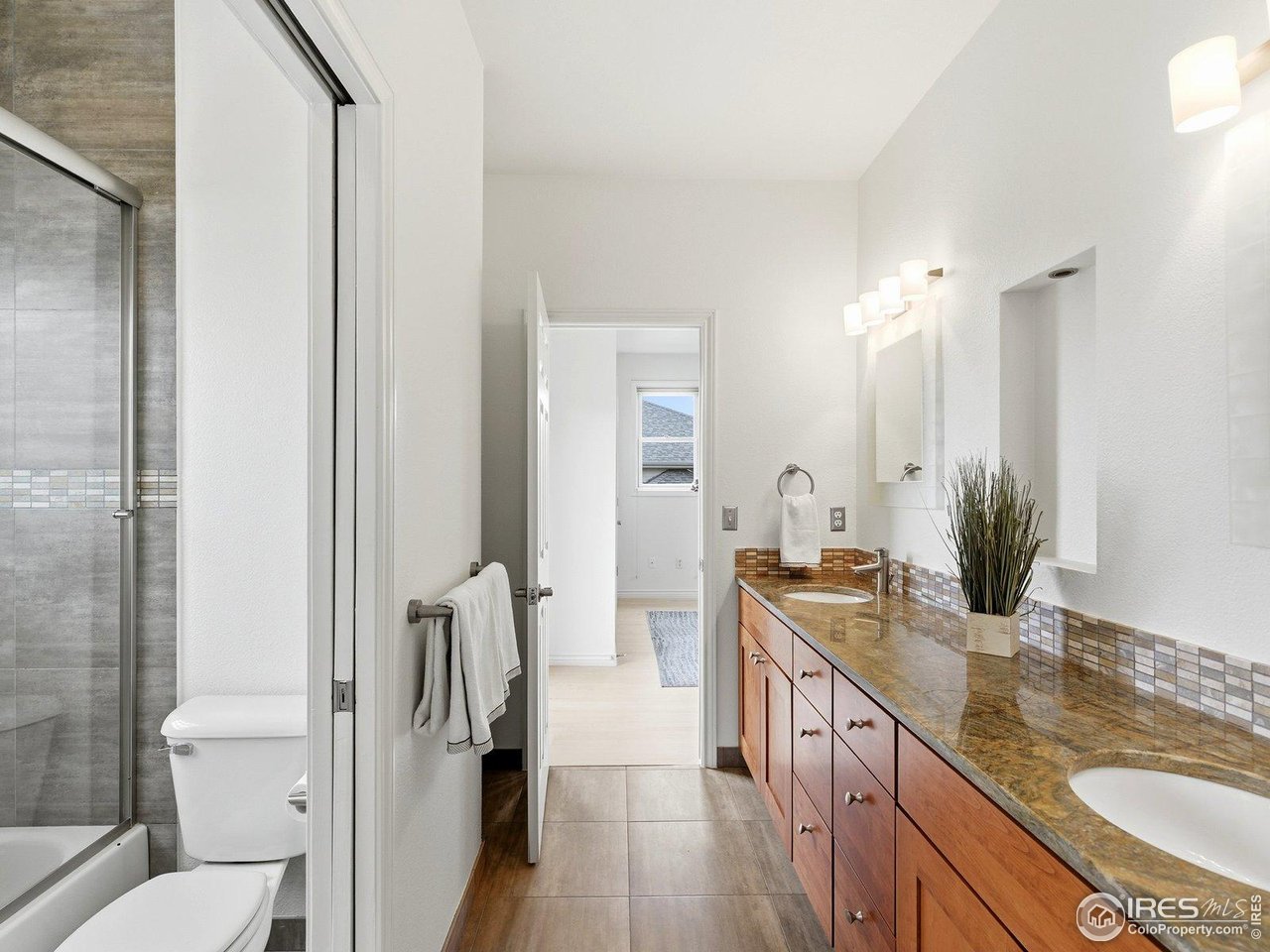 4796 6th Street Boulder, CO 80304 - Photo 31 of 47 a spacious bathroom with a granite countertop sink mirror and a toilet