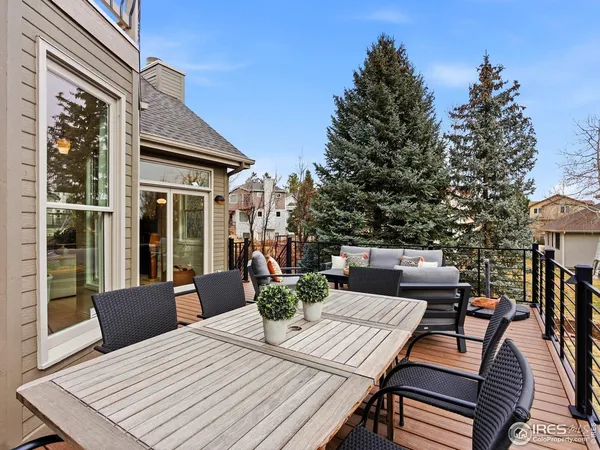 a view of a roof deck with table and chairs couches and wooden floor
