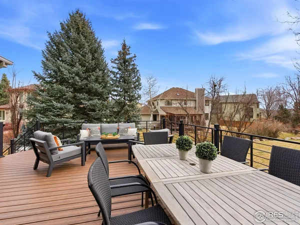 a view of a patio with table and chairs with wooden floor and fence