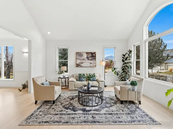 a living room with furniture potted plant and a large window