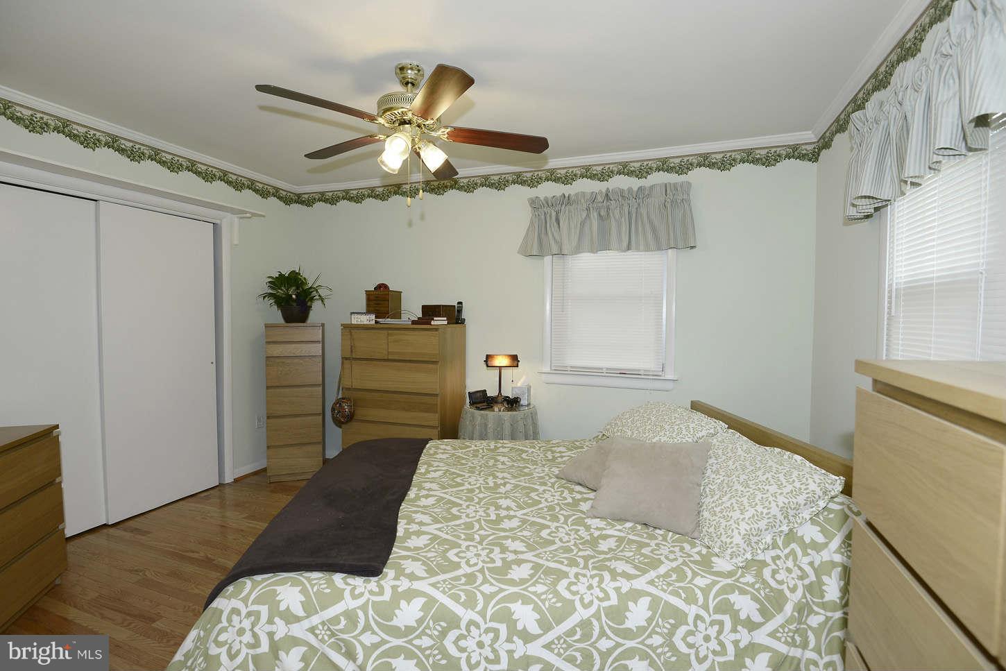 12110 Selfridge Road Silver Spring, MD 20906 - Photo 16 of 26 a bedroom with a bed and a chandelier