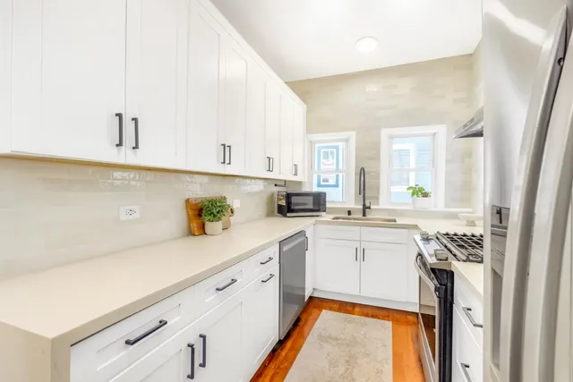 a kitchen with cabinets appliances a sink and a counter top space