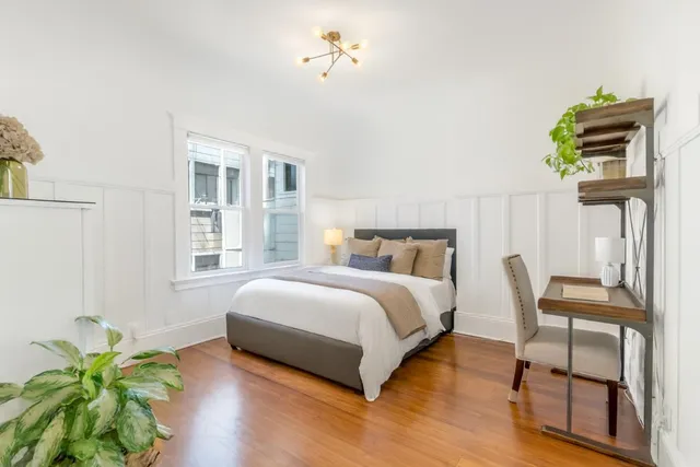 a bedroom with a bed table and a chair