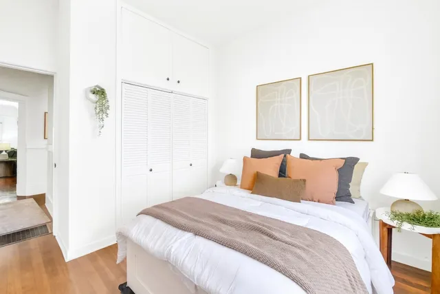 a bedroom with a bed and wooden floor