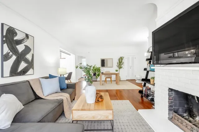a living room with furniture a flat screen tv and a fireplace