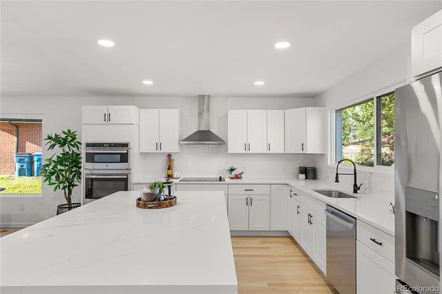 a kitchen with stainless steel appliances kitchen island granite countertop a sink and cabinets