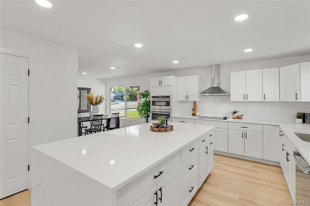 a large white kitchen with stainless steel appliances