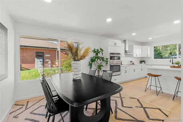 a bed sitting in a bedroom next to a window and potted plant