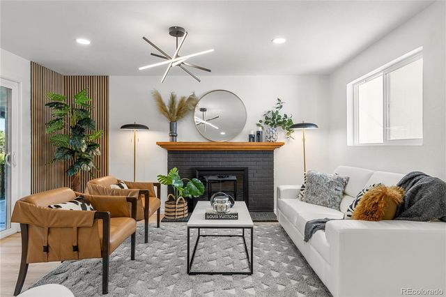 a living room with furniture a potted plant and a fireplace