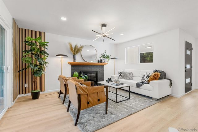 a living room with furniture a fireplace and a potted plant