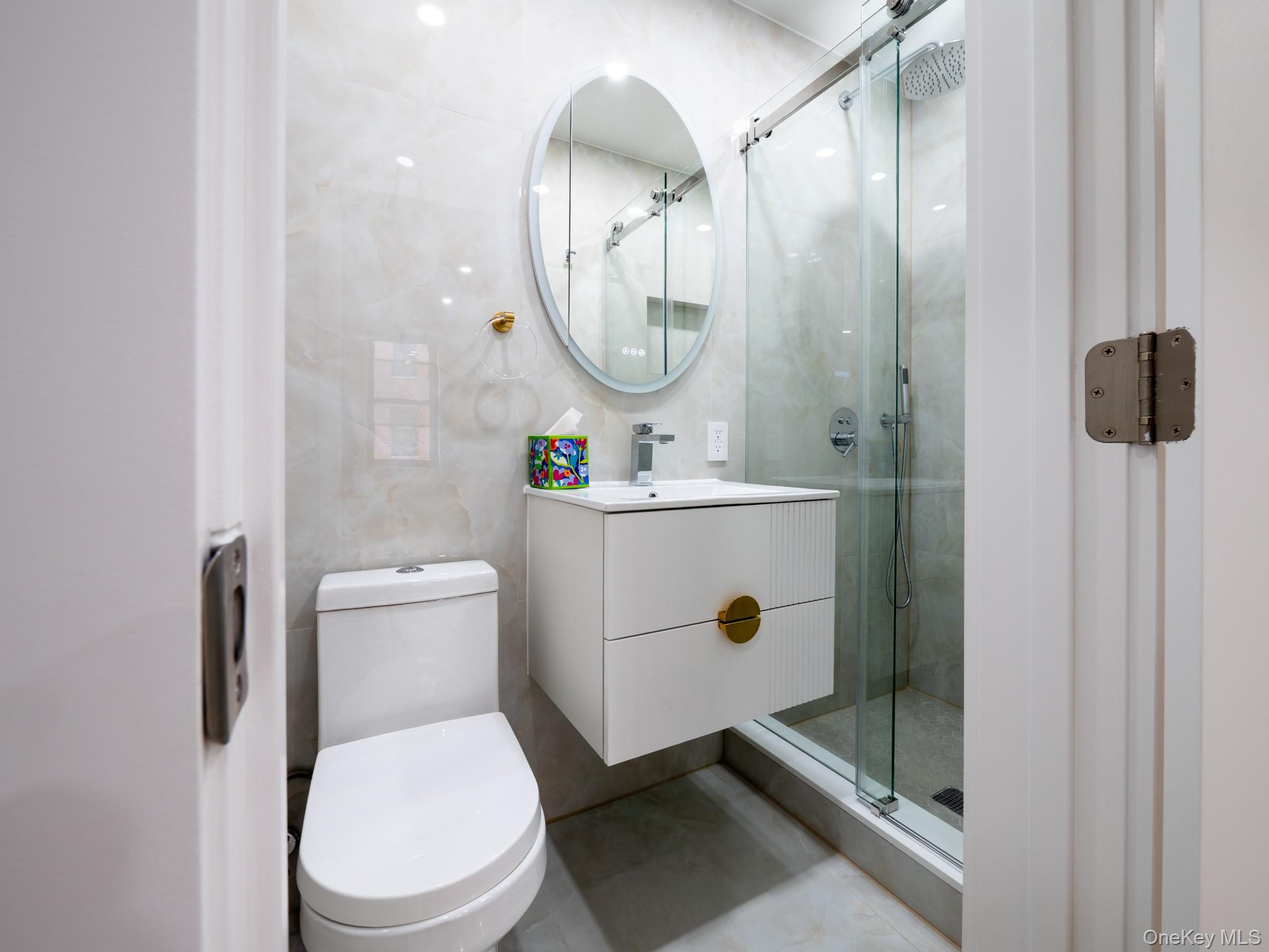 139-15 83rd Avenue, Unit 423 Queens, NY 11435 - Photo 13 of 24 Full bathroom featuring vanity, a shower stall, and tile walls