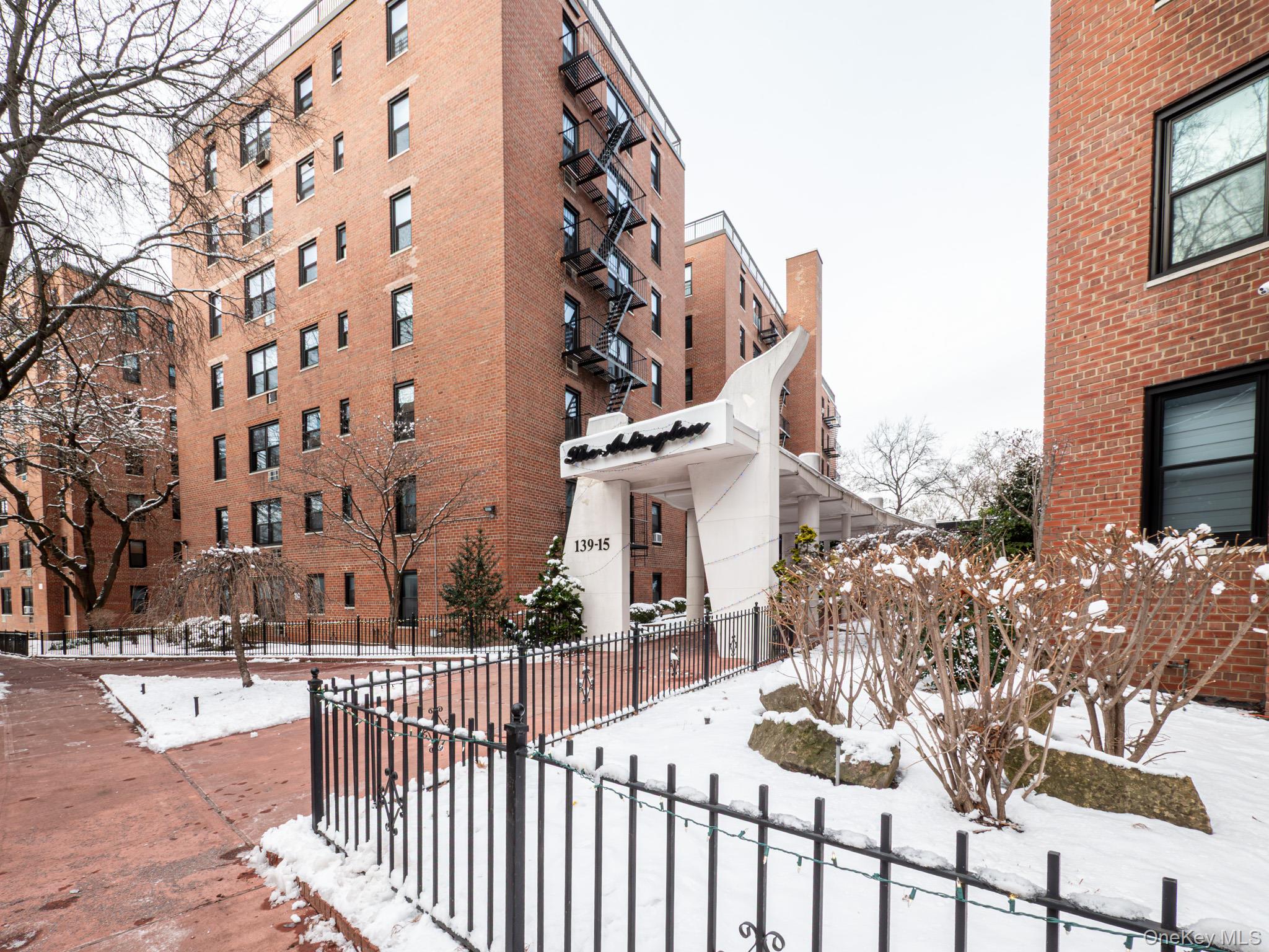 139-15 83rd Avenue, Unit 423 Queens, NY 11435 - Photo 18 of 24 Snow covered building with a view of apartment building / complex and a fenced front yard