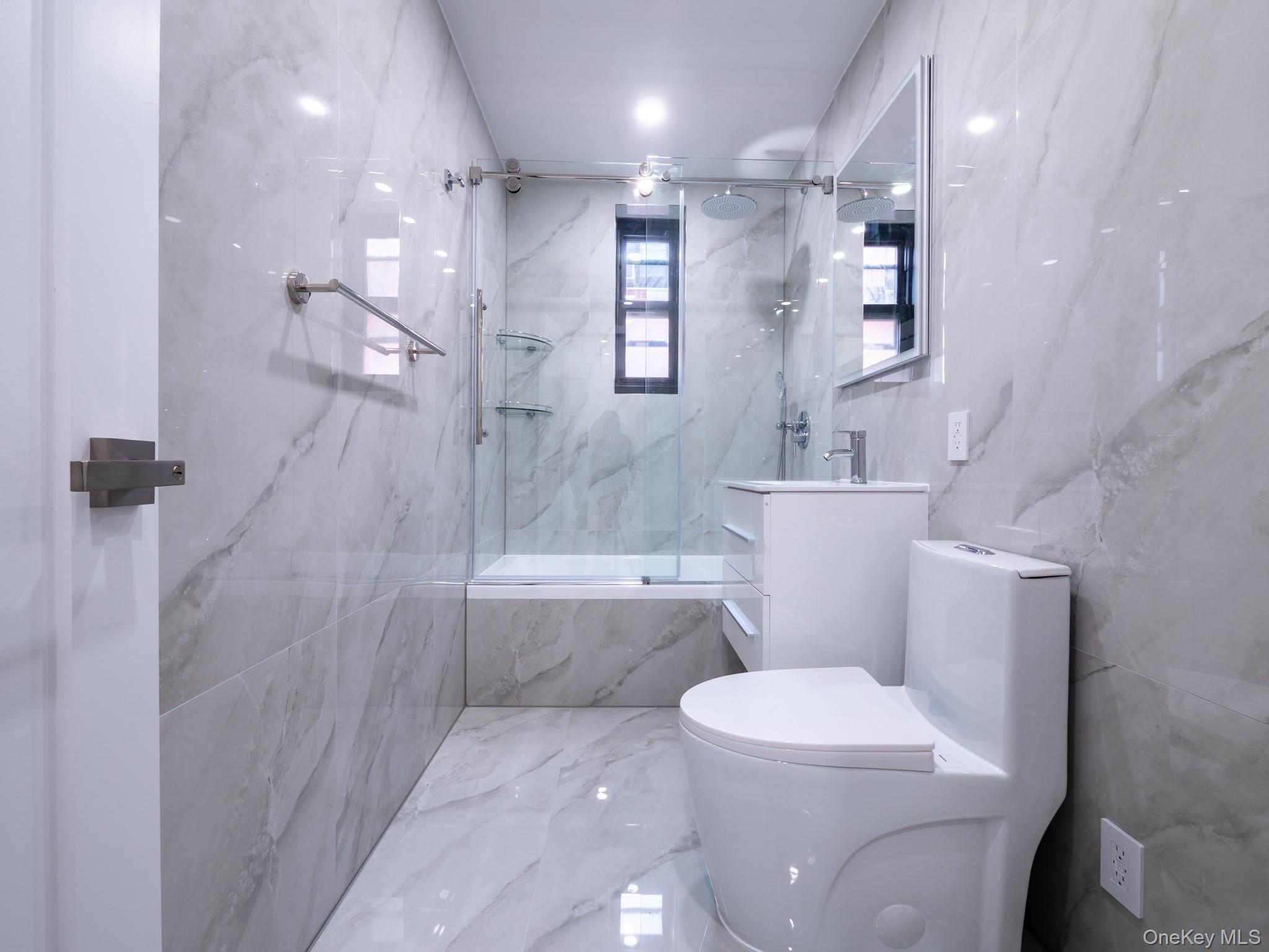 139-15 83rd Avenue, Unit 423 Queens, NY 11435 - Photo 6 of 24 Bathroom with a marble finish shower, vanity, marble tiled flooring, and stone wall