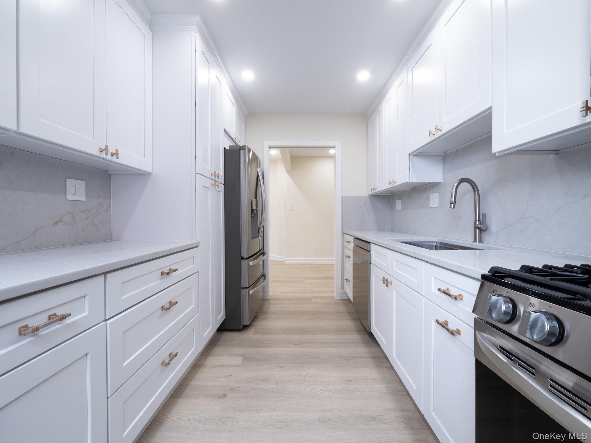 139-15 83rd Avenue, Unit 423 Queens, NY 11435 - Photo 7 of 24 Kitchen with decorative backsplash, white cabinets, appliances with stainless steel finishes, and recessed lighting