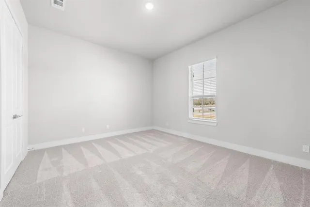 an empty room with a ceiling fan and window