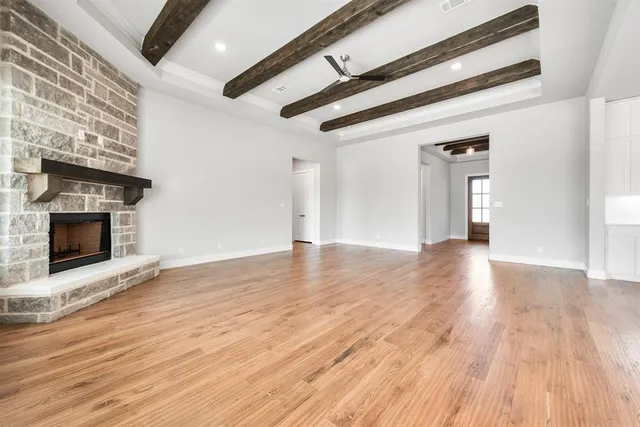a view of empty room with wooden floor and fireplace