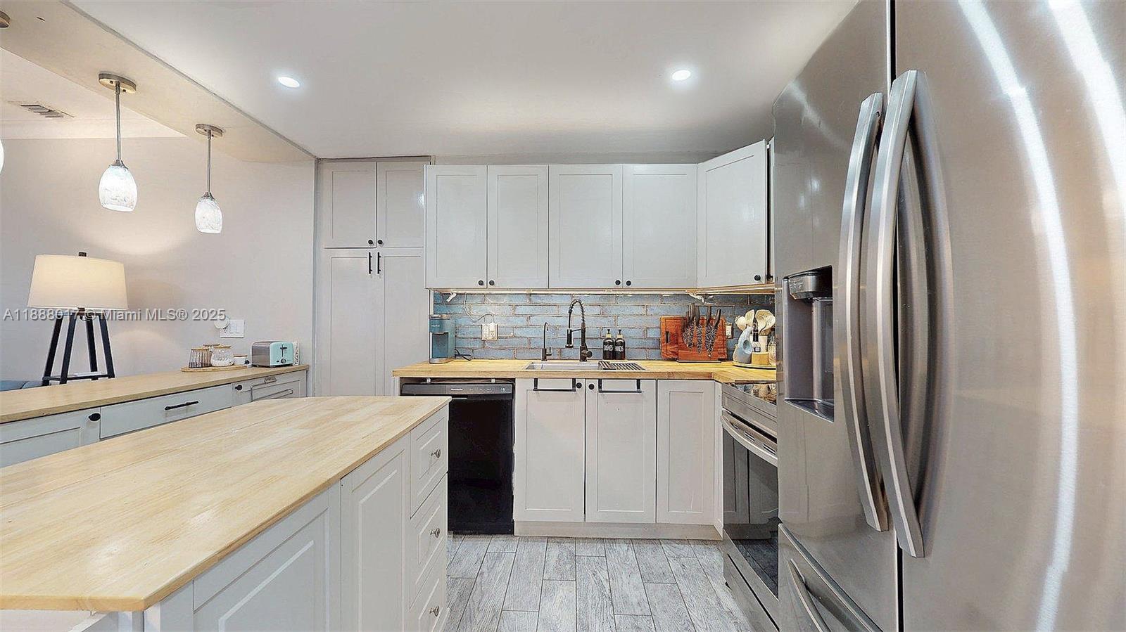 18475 Southwest 204th Street Miami, FL 33187 - Photo 11 of 41 a kitchen with a sink a refrigerator and cabinets