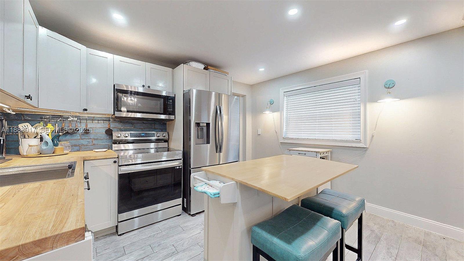 18475 Southwest 204th Street Miami, FL 33187 - Photo 12 of 41 a kitchen with stainless steel appliances a stove a sink refrigerator and a refrigerator