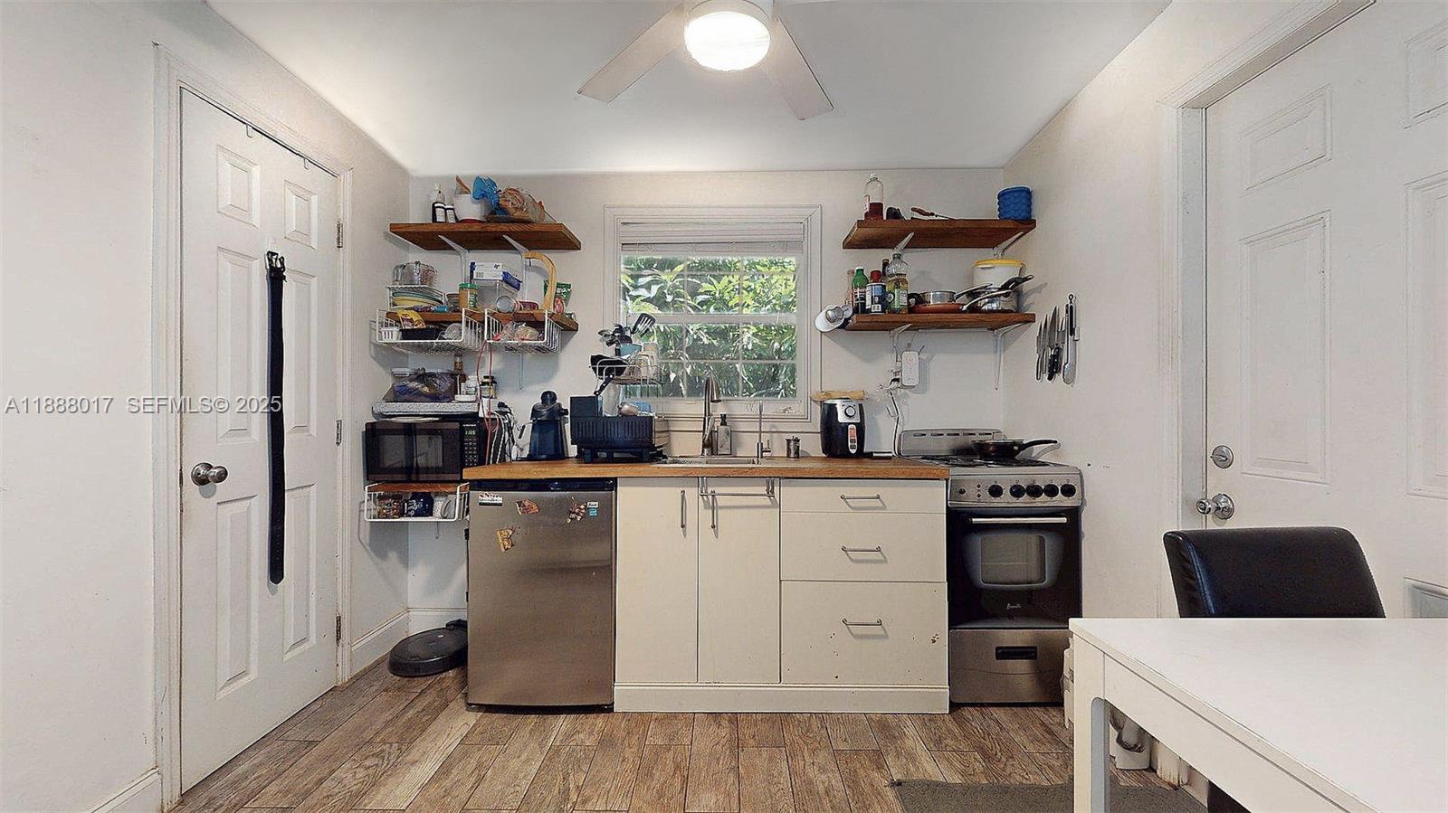 18475 Southwest 204th Street Miami, FL 33187 - Photo 38 of 41 a kitchen with stainless steel appliances a stove and white cabinets