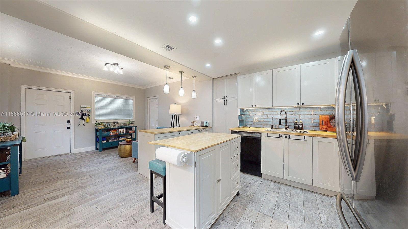 18475 Southwest 204th Street Miami, FL 33187 - Photo 9 of 41 a kitchen with stainless steel appliances granite countertop a refrigerator a sink dishwasher and a stove with wooden floor