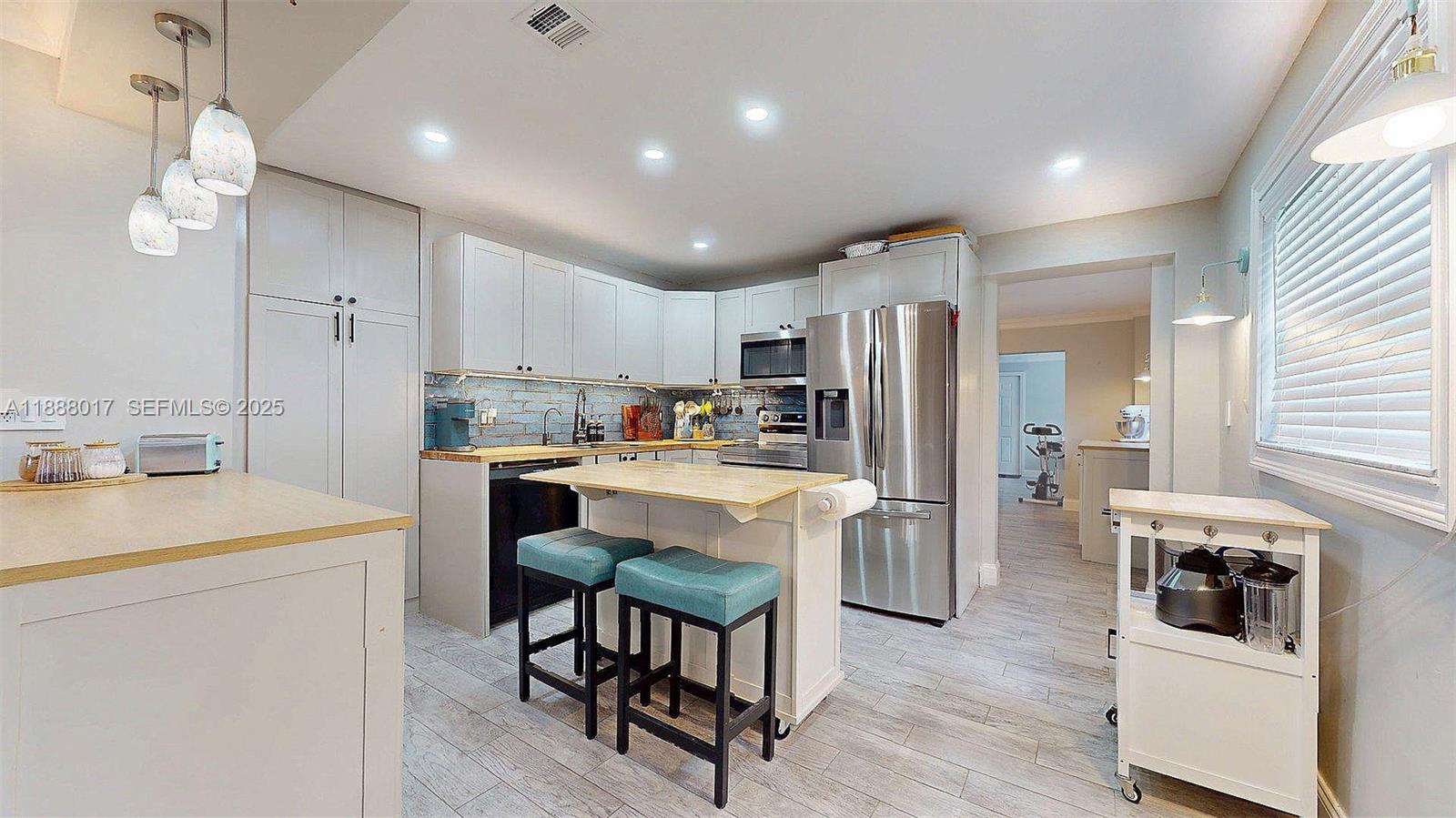 18475 Southwest 204th Street Miami, FL 33187 - Photo 10 of 41 a kitchen with white cabinets and stainless steel appliances