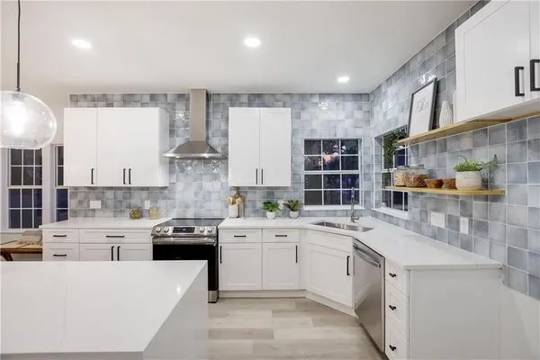 a large white kitchen with a lot of counter space and appliances