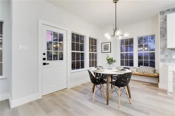 a kitchen with kitchen island a dining table chairs and wooden floor