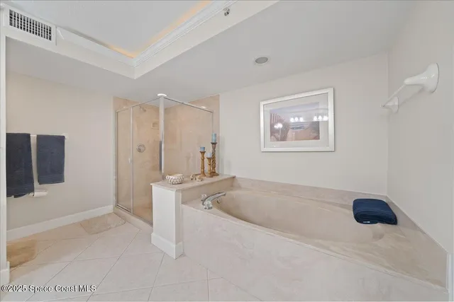 a spacious bathroom with a tub shower and mirror