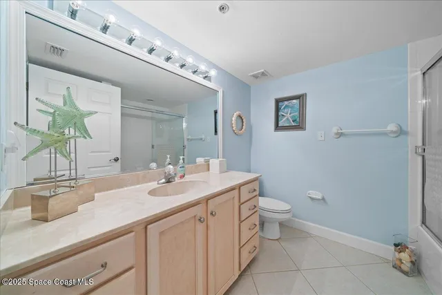 a bathroom with a granite countertop sink a toilet and a mirror