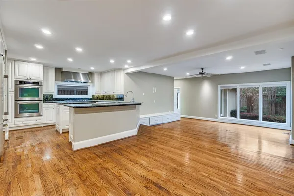 a view of kitchen with kitchen island wooden floor appliances and center island